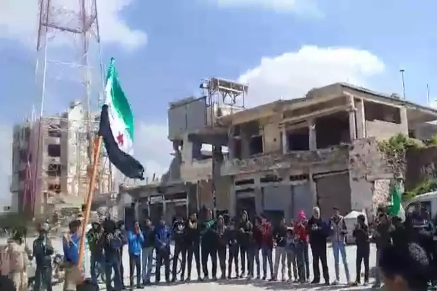 في الذكرى الثامنة ... متظاهرون يرفعون علم الثورة السورية في ساحة المسجد العمري بدرعا البلد