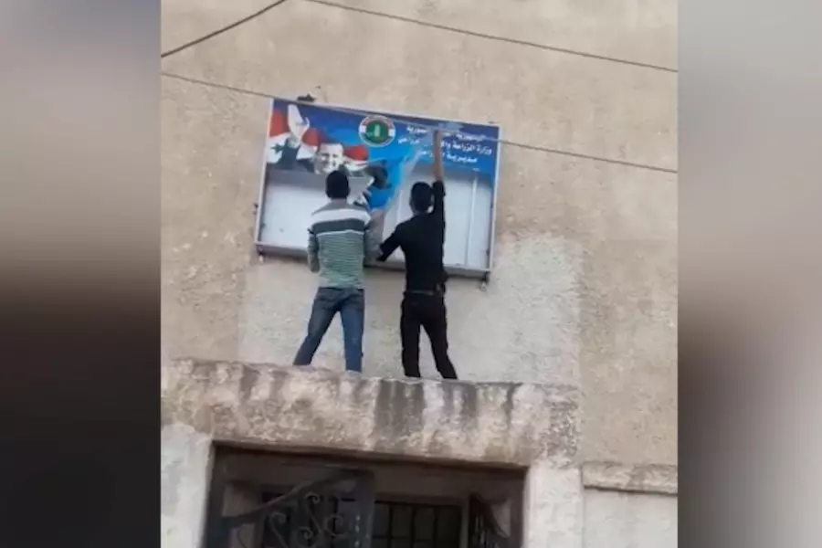شبان مدينة الصنمين شمالي درعا يمزقون صورة المجرم بشار الأسد