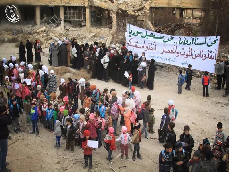 مطالبين بفك الحصار ووقف القصف أهالي داريا يعتصمون على أنقاض المباني المدمرة