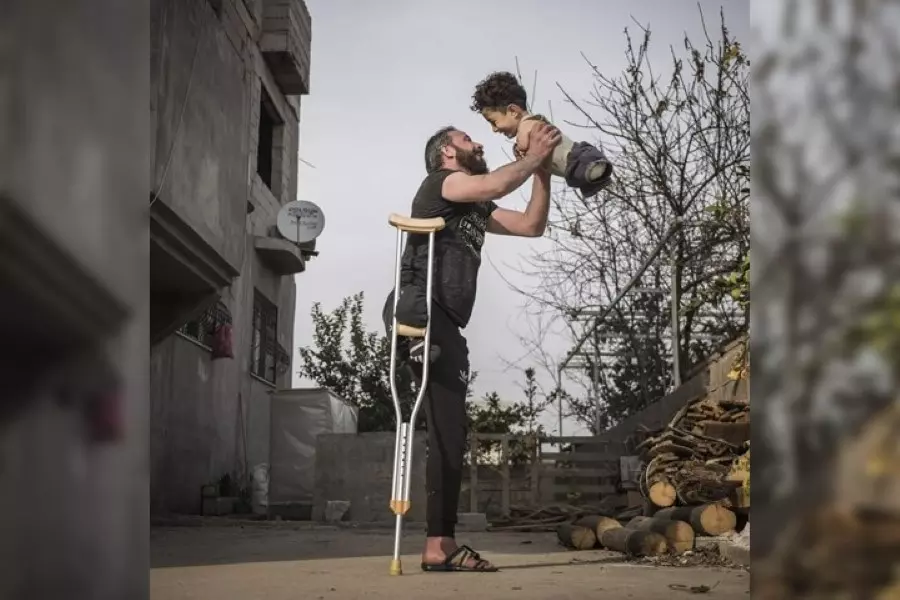 صورة مؤلمة لأب سوري يحمل طفله بدون أطراف تفوز بجائزة سيينا الدولية لعام 2021